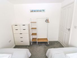 A bedroom with a dresser and a clothes rack at 69 Ffordd Y Meillion in Llanelli
