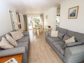 A living room with two grey sofas and a dining area with white chairs at Forbes C1 in Yarmouth