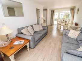 A living room with two grey sofas and a wooden coffee table next to a dining area with a table and chairs at Forbes C1 in Yarmouth