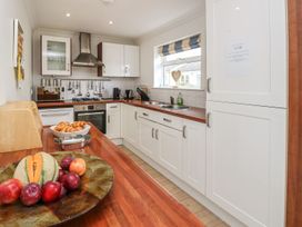 A kitchen with wooden countertops white cabinets a window and fruit on a plate at Forbes C1 in Yarmouth