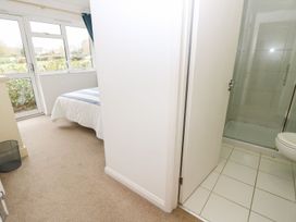 A bedroom with a bed near a window and an adjacent bathroom with a shower at Forbes C1 in Yarmouth