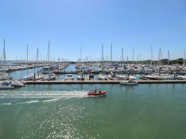 A marina with many sailboats docked and a small motorboat on the water at Forbes C1 in Yarmouth