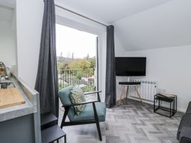 A living room with a television and sofa at Claife Flights in Bowness-On-Windermere