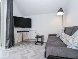 A living room with a sofa and a TV at Claife Flights in Bowness-On-Windermere