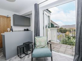 A living room with a balcony view at Claife Flights in Bowness-On-Windermere