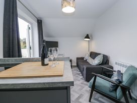 A living room with a sofa and wine glasses at Claife Flights in Bowness-On-Windermere