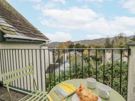 An outdoor terrace with a table, croissant, and coffee cups at Claife Flights in Bowness-On-Windermere