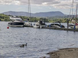 A lake with boats and ducks at Claife Flights Bowness-On-Windermere