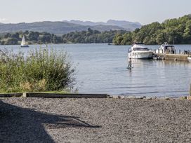A person on a paddleboard near boats at Claife Flights in Bowness-On-Windermere