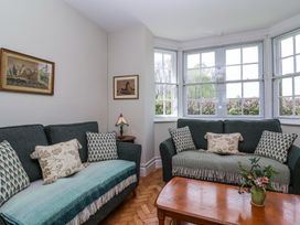 A sitting room with two sofas and a wooden coffee table with flowers at Middle Lodge near Taunton