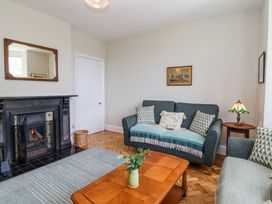 A living room with sofas a wooden coffee table a fireplace and a side table with a lamp at Middle Lodge near Taunton