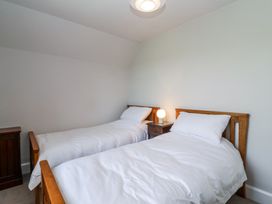 A bedroom with two single beds and a bedside table with a lamp at Middle Lodge near Taunton