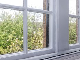 A view of green trees and white flowers through a window at Middle Lodge near Taunton