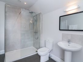 A bathroom with a shower area a toilet a sink and a mirror at Middle Lodge near Taunton