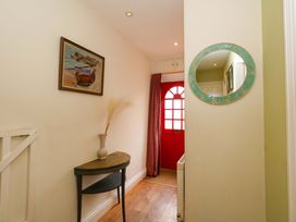 A hallway with a table and a painting at Garden Retreat in Swanage