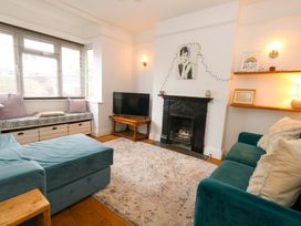 A living room with a sofa, tv, and fireplace at Garden Retreat in Swanage