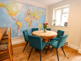 A dining room with a round table and chairs at Garden Retreat in Swanage