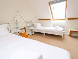 A bedroom with two beds and a nightstand at Garden Retreat in Swanage