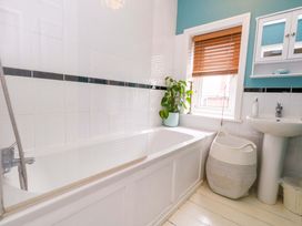 A bathroom with a bathtub and sink at Garden Retreat in Swanage