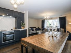 A kitchen and living room area with a dining table and couch at Tyn Y Coed