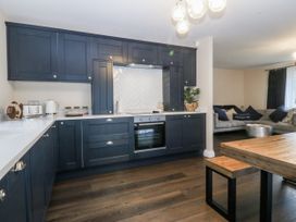 A kitchen with dark cabinets and a table at Tyn Y Coed
