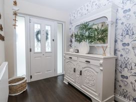 A hallway with a front door and a dresser at Tyn Y Coed in 