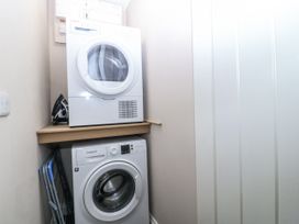 A washing machine and dryer stacked in a laundry room at Tyn Y Coed