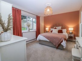 A bedroom with a bed, curtains, and window at Tyn Y Coed