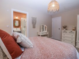 A bedroom featuring a bed, dressing table, mirror and a shower at Tyn Y Coed 