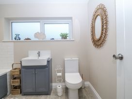 A bathroom with a sink, toilet, and window at Tyn Y Coed 