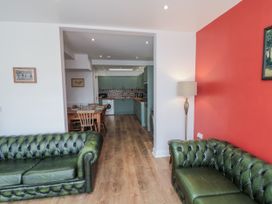 A living room with green sofas and a view of the kitchen at Number 33 in Scarborough