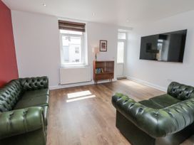 A living room with green sofas and a table at Number 33 Scarborough