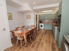 A kitchen with a wooden dining table and green cabinets at Number 33 in Scarborough