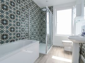 A bathroom with a bathtub, shower, toilet and sink at Number 33 Scarborough