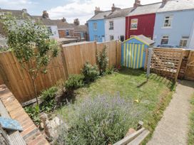 A garden with a wooden fence and a blue and yellow shed at Number 33 Scarborough