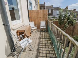 A balcony with wooden flooring and chairs at Number 33 in Scarborough