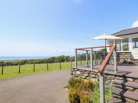 A patio area with furniture overlooking a field at Ysgubor Newydd Parc Isaf Dyffryn Ardudwy
