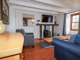 A living room with a fireplace and sofa at Rose Cottage in Falmouth
