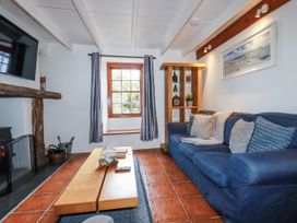 A living room with a sofa and coffee table at Rose Cottage in Falmouth