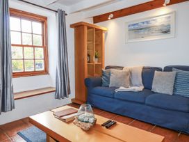 A living room with a sofa and coffee table at Rose Cottage in Falmouth