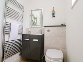 A bathroom with a towel radiator, sink, mirror, and toilet at Miramar in St. Ives