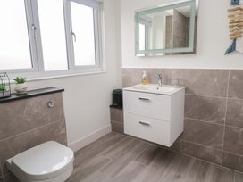 A bathroom with a sink, toilet, and mirror at Miramar in St. Ives