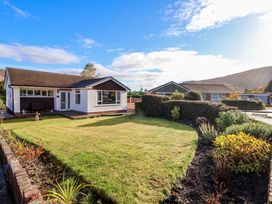 A single-story house with a front lawn and garden beds at Green View in Llangollen