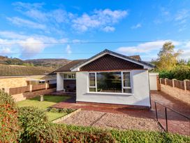 A single-story house with a large front window a driveway and garden at Green View in Llangollen