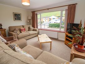 A living room with sofas cushions a coffee table a television and a plant at Green View in Llangollen