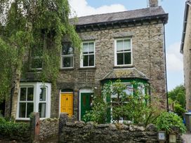 A house with yellow and green doors and garden at 28 Rock Villas in Carnforth