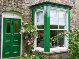 A green door and window with plants at 28 Rock Villas in Carnforth