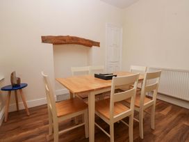 A dining room with a wooden table and six chairs at 28 Rock Villas in Carnforth