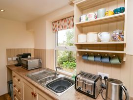 A kitchen with a sink and kitchen appliances at 28 Rock Villas in Carnforth