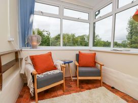 A conservatory with armchairs and a table at 28 Rock Villas in Carnforth